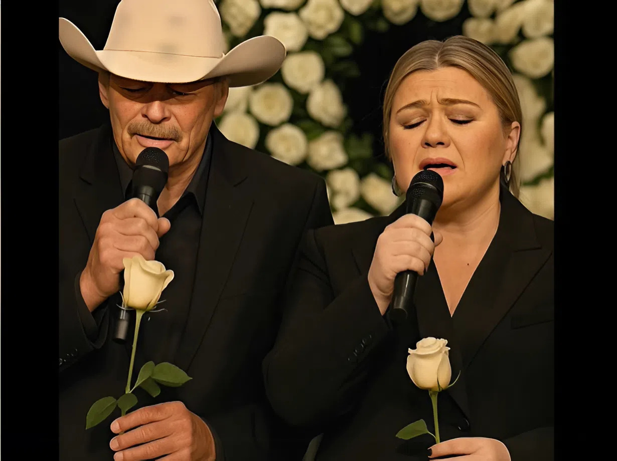 Cover Image for When Alan Jackson quietly entered the private memorial service in Nashville, many assumed he would simply pay his respects and leave. But as the ceremony unfolded, and Kelly Clarkson sat silently in the front row holding back tears, Alan stepped forward — not as a star, but as a friend. In a brief, trembling statement, he turned to Kelly and said: “When hearts break, music holds them together. Let’s sing him home.” What followed was an unforgettable duet between Alan Jackson and Kelly Clarkson, performed completely a cappella beneath a canopy of white roses in the fading glow of the sunset. The song, “I Will Always Love You” — once immortalized by both Dolly Parton and Whitney Houston — took on new meaning as it drifted through the chapel like a whispered goodbye.