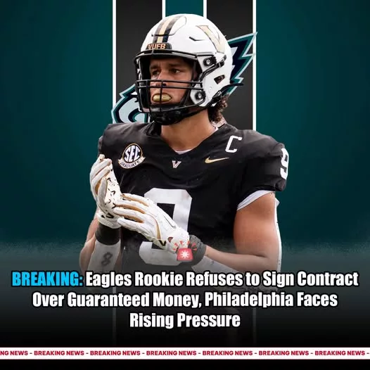 Cover Image for 🚨TENSION BUILDING IN PHILLY… AND THIS STORY IS FAR FROM OVER 🚨 A second-round rookie for the Philadelphia Eagles is reportedly refusing to sign his contract—and it’s not just about the money. Sources say the dispute revolves around guaranteed terms, respect, and long-term protection within the deal. Pressure is mounting inside the organization as time passes without an agreement. Fans are starting to split: should the team stand firm, or give the rookie what he wants to secure his future? This could become a defining moment for both sides—and all eyes are on who blinks first. 👀